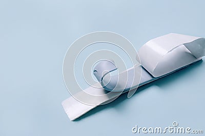 Blu Tack in a shape of thin flat strip on blue background Stock Photo