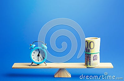 Blue alarm clock and a bundle of euro on scales. Fair hourly wages. Profitability and return on investment. Rental. Balance Stock Photo