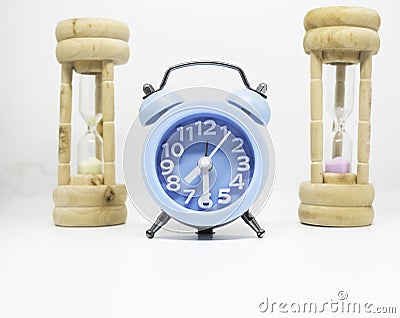 Blue Alarmclock put at the middle of wood sandclock Stock Photo