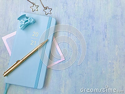 Blue new diary with golden 2021 words, golden pen, blue hairpin, golden jewelry, blue background Stock Photo