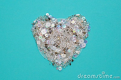 Blue background with heart of sequins and beads Stock Photo