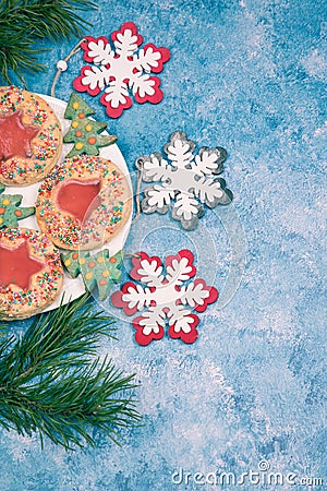 On a blue background, a plate with handmade Christmas cookies and Christmas snowflakes . Vertical orientation. Copy Stock Photo