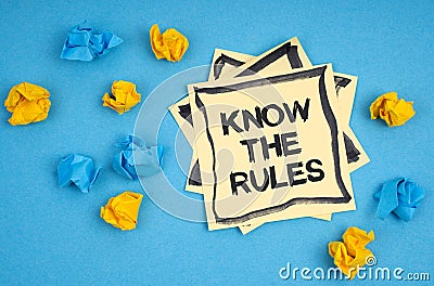 On a blue background, there are pieces of paper and a sticker with the inscription - KNOW THE RULES Stock Photo