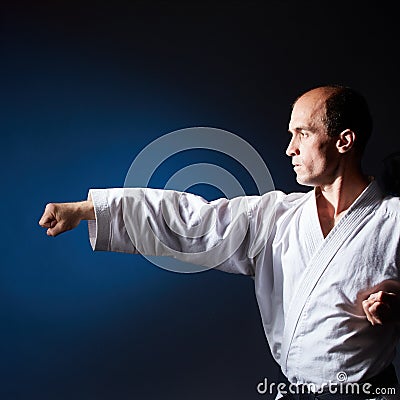 On a blue background a young athlete makes a punch arms Stock Photo