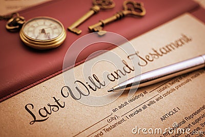 Blue ballpoint pen, antique pocket watch, two brass keys and a last will and testament on a vinyl desk pad. Stock Photo