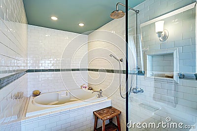 Blue bathroom interior with white tile trim wall, glass cabin shower and bath tub. Stock Photo