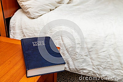Bible on nightstand in hotel room Stock Photo