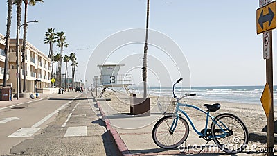 Bicycle cruiser bike by ocean beach, California coast USA. Summer cycle, lifeguard tower and palms. Stock Photo