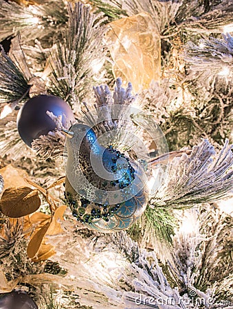 A blue bird Christmas ornament on a flocked Christmas tree Stock Photo