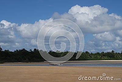 Blue boat, on beautiful blue sky and cotton-clouds background at Ponta do Muta, Barra Grande, Marau Peninsula, Bahia State, Brazil Stock Photo