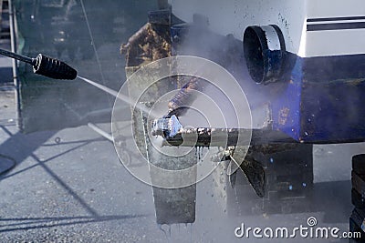 Blue boat hull cleaning pressure washer barnacles Stock Photo