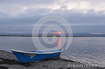 Blue boat at the lake shore at sunset Editorial Stock Photo