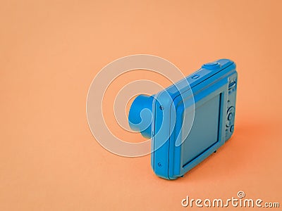 A blue camera with a retractable lens on a brown background Stock Photo