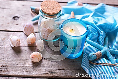 Blue candle and marine items on aged wooden background. Stock Photo