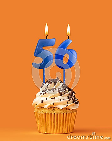 Blue candle number 56 - Birthday cupcake on orange background Stock Photo