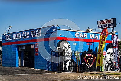 blue car wash with graffiti on the side and large sign on building Editorial Stock Photo