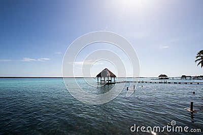 blue Caribbean sea with crystal clear waters and clear sky. a bungalow with a pier in the middle of the lagoon in a coral Stock Photo
