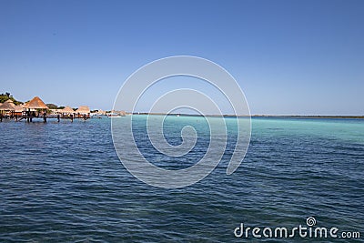 Caribbean sea with crystal clear waters and clear sky. a bungalow with a pier in the middle of the lagoon in a coral Stock Photo