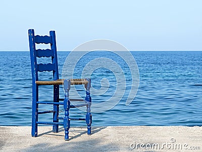 Blue chair at the sea in Greece Stock Photo