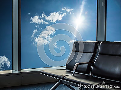 Blue chairs for sitting in the airport with blue sky and sunlight outside the window Stock Photo