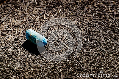 Chalk colored in the sun on a textured black floor Stock Photo