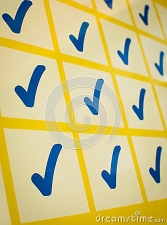 Blue checkmarks in yellow grid Stock Photo