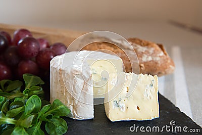 Blue cheese on a plate with grapes. Stock Photo