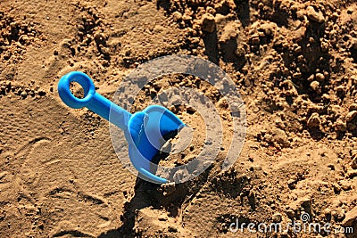 Blue childrens spatula, stuck in sand Stock Photo