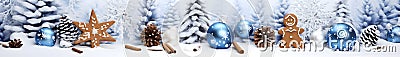 Blue Christmas balls and gingerbread in a row with spruce and fir trees in the background. Stock Photo