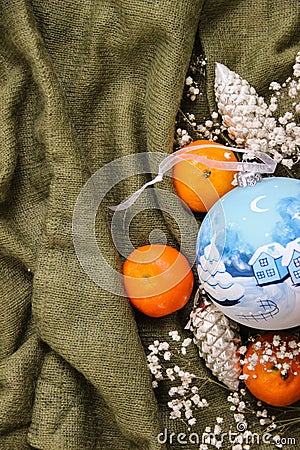 Blue Christmas tree toy. Painted Christmas tree ball. Handmade and vintage Christmas tree toys, mandarins and gypsophila. Stock Photo