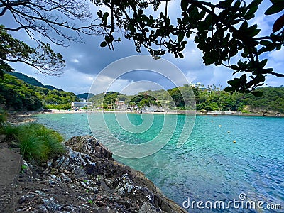 Blue coastline and people on the beach in the background of the Izu Peninsula in Honshu, Japan Stock Photo