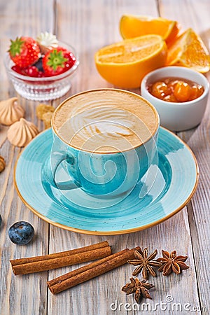 Blue coffee cup with cappuccino, cinnamon and anise. Breakfast concept Stock Photo