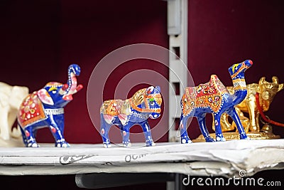 Blue coloured Elephant, camel, horse figurines displayed for sale in a shop. Various Traditional local handicraft. Selective focus Stock Photo