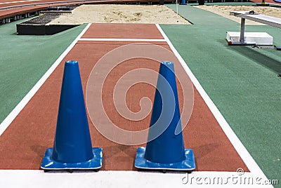 Blue cones blocking long jump pit indoors Stock Photo