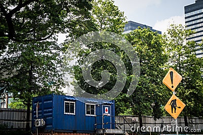 Blue container house as office or house with green tree as background and big building Editorial Stock Photo