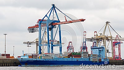 Blue container ship anchoring at a harbor crane Editorial Stock Photo