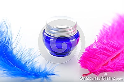Blue cosmetic bottle with two decorative ostrich feathers isolated on white background Stock Photo