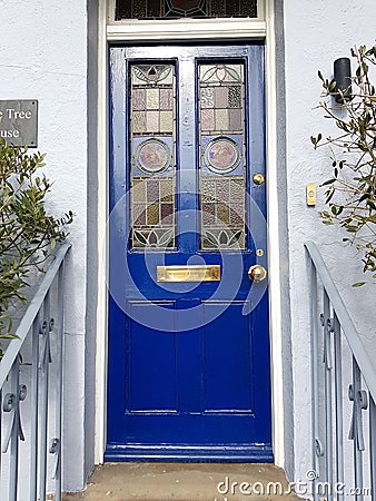 A blue cottage door with a stained glass window. Editorial Stock Photo