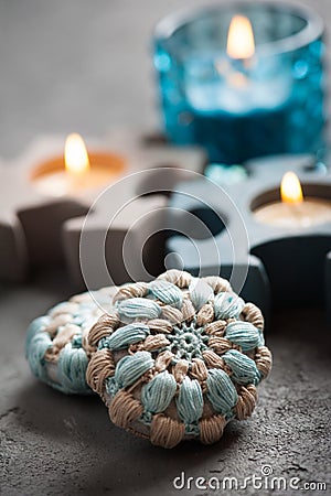 Blue crochet stones and lit candles Stock Photo