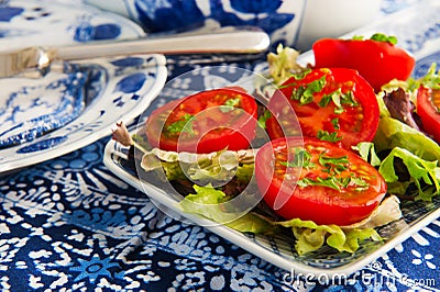 Blue crockery with fresh tomatoes Stock Photo