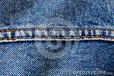 Blue denim jeans with middle brown yellow color sewing thread seam macro closeup textile background Stock Photo
