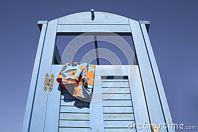 Blue dress cabin at the beach with a swimming suit hanging out Stock Photo