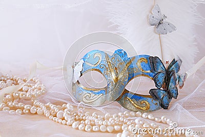 blue elegant venetian mask next to pearls Stock Photo