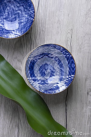 Blue empty bowls for soup or noodles on wooden background with leaf. Oriental layout Stock Photo