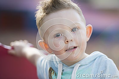 Blue eyed boy pauses while playing at a park in Australia Stock Photo