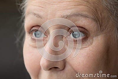 Blue eyes of thoughtful senior 70 woman looking away Stock Photo