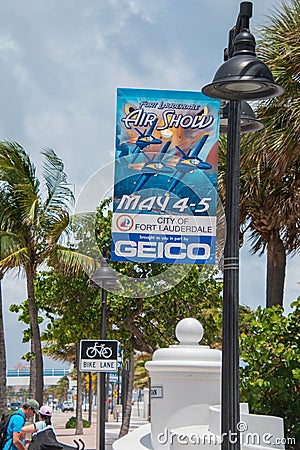 Blue fabric sign on a lamp post advertising the Fort Lauderdale Air Show that took place on May 4th and 5th. There are palm trees Editorial Stock Photo