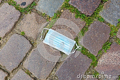 Blue face mask on cobblestone. Stock Photo