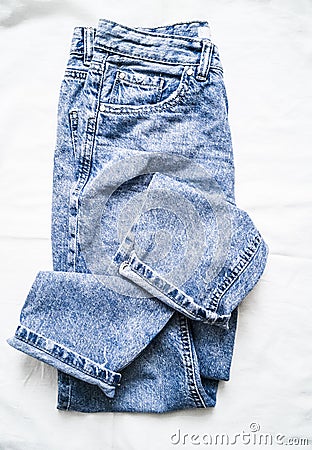 Blue faded mom jeans on a light background, top view. Fashion clothing Stock Photo