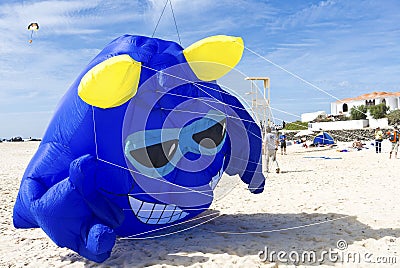 Blue fantasy monster kite taking off for blue skies at the beach Stock Photo